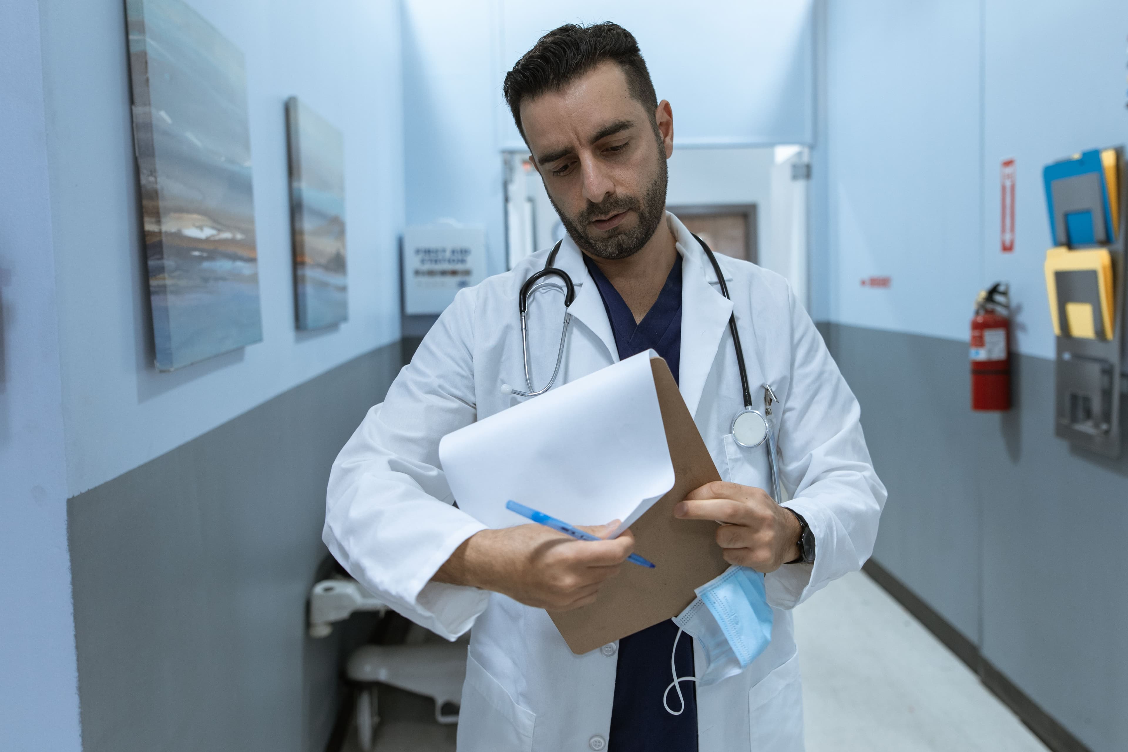 Physician reviewing a chart in a hospital corridor